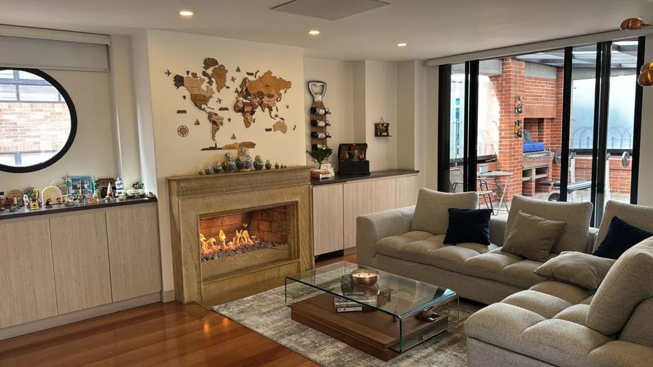 Sala de un apartamento usado con chimenea y amplios ventanales